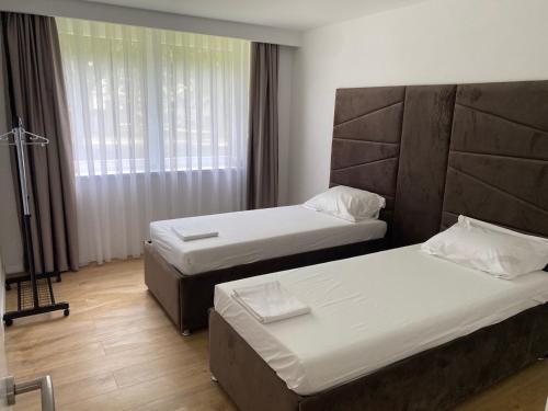 a hotel room with two beds and a window at Mia apartman Visoko in Visoko