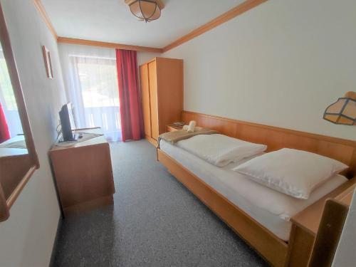 a hotel room with a bed and a television at Berghotel Türlwand in Ramsau am Dachstein
