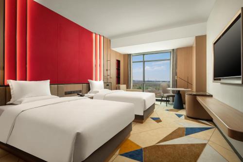 a hotel room with two beds and a flat screen tv at La Quinta by Wyndham Weifang South in Weifang