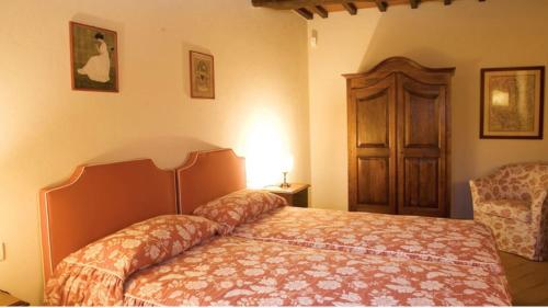 a bedroom with a bed and a chair in a room at MAGNOLIA e CAMELIA in Vicchio