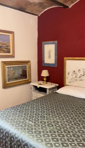 1 dormitorio con 1 cama y 1 mesa con lámpara en Casa Romano, en Manciano