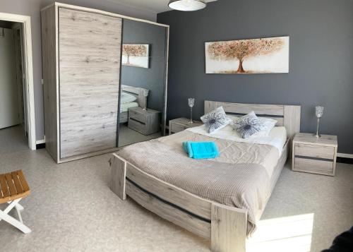 a bedroom with a large bed with blue pillows at B&B Den Boskant in Zandbergen