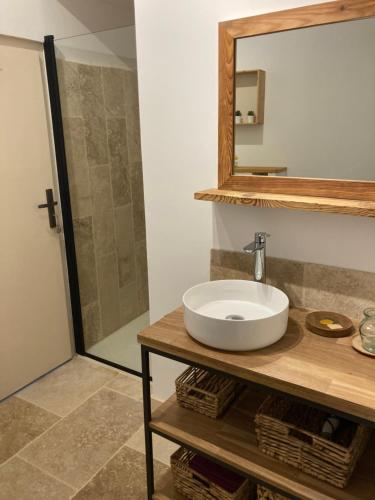 une salle de bain avec un lavabo et un miroir dans l'établissement Le mas de Marie, à Taulignan