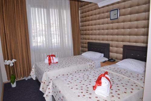 a hotel room with two beds with red bows at Kervan Hotel Pendik in Istanbul