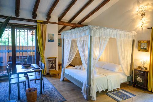 una camera con letto a baldacchino e scrivania di Villa Pusiana a Cesana Brianza