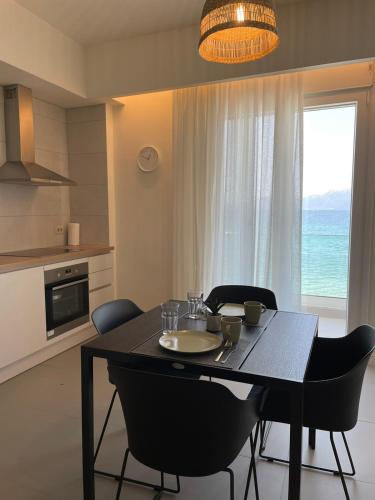 a dining room with a table and chairs and a window at By The Sea - Paleros in Paleros