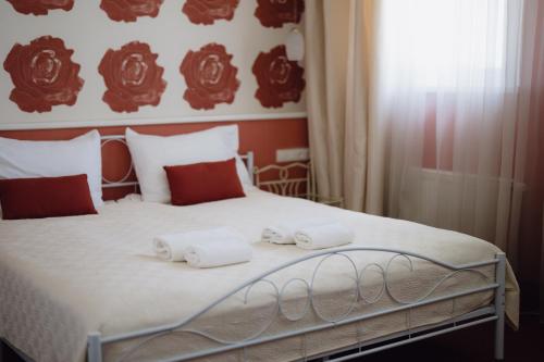 a bedroom with a bed with towels on it at Moon Garden Old Town Hotel in Vilnius