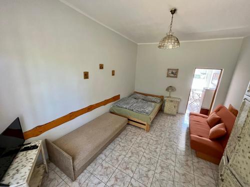 a bedroom with a bed and a couch and a chair at Słowińska Natura in Smołdziński Las