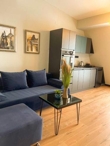 a living room with a blue couch and a table at Living Rooms in Skopje