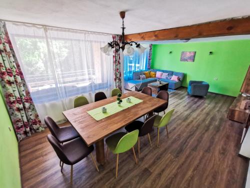 a dining room with a wooden table and chairs at Вила Край реката in Botevgrad