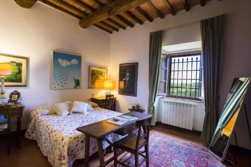 Schlafzimmer mit einem Bett, einem Tisch und einem Fenster in der Unterkunft Le Rose di Montagnana in San Gimignano