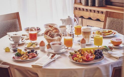 a table topped with plates of food and drinks at Hotel Waldhuus in Davos