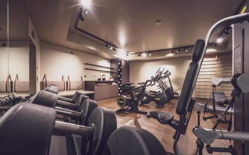 a gym with bikes and exercise equipment in a room at Hotel Waldhuus in Davos