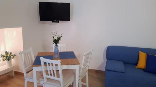 salon ze stołem i niebieską kanapą w obiekcie La Chicca w mieście Ostuni