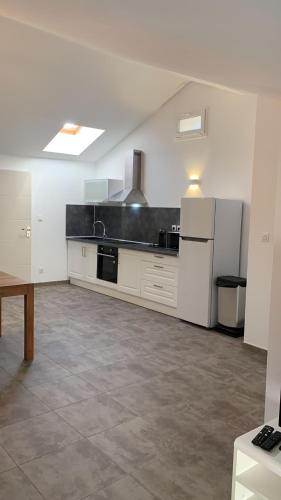 une grande cuisine avec des armoires et des appareils blancs dans l'établissement Appartement rue de Provence, à Avignon