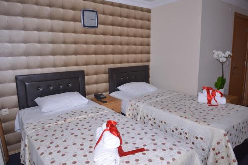 a woman sitting on a bed in a room with two beds at Kervan Hotel Pendik in Istanbul