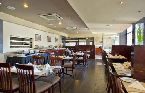 una sala da pranzo con tavoli e sedie e un ristorante di Hotel Thuringerhof a Windhoek