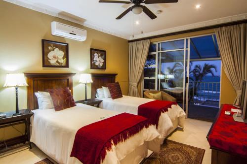 a hotel room with two beds and a balcony at Burnham House B&B in Durban