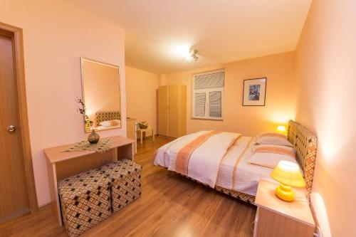 a bedroom with a bed and a table and a mirror at Apartments Bokan in Cetinje