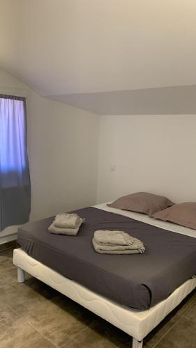 - un lit dans une chambre avec 2 serviettes dans l'établissement Appartement rue de Provence, à Avignon