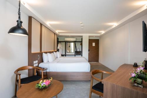 a hotel room with a bed and a table and chairs at Dewa Phuket Resort & Villas, Nai Yang Beach in Nai Yang Beach