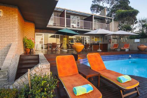 a patio with two chairs and a swimming pool at Burnham House B&B in Durban
