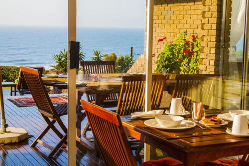 a table and chairs on a patio with the ocean at Burnham House B&B in Durban