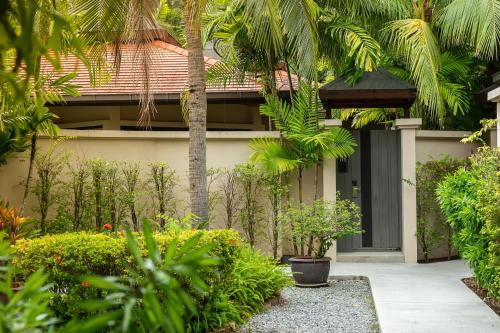 a house with a courtyard with trees and plants at Dewa Phuket Resort & Villas, Nai Yang Beach in Nai Yang Beach