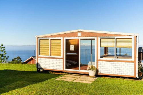 a tiny house sitting on the grass near the ocean at Kaz Noulafé in Saint-Leu