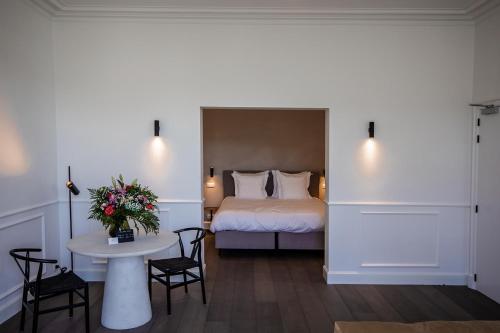 a hotel room with a bed and a table with chairs at Villa Ostinato in Ostend