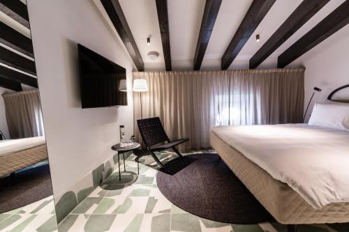 a hotel room with a bed and a chair at Concepcio by Nobis, Palma, a Member of Design Hotels in Palma de Mallorca