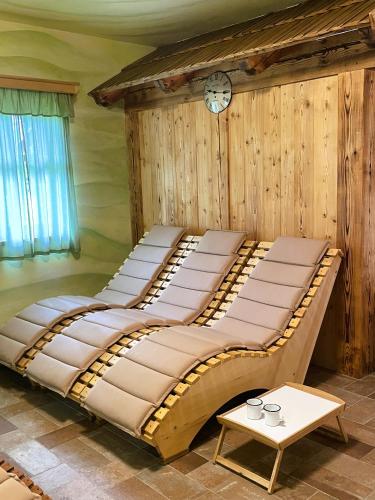 a large bed in a room with a clock on the wall at Penzion Kovárna in Bukvice