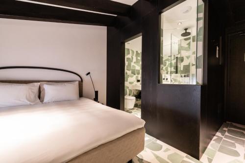 a bedroom with a white bed and a mirror at Concepcio by Nobis, Palma, a Member of Design Hotels in Palma de Mallorca