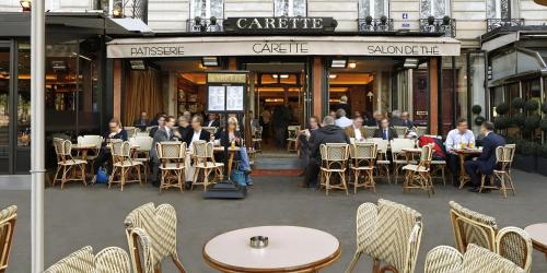 Un groupe de personnes assises à des tables devant un café dans l'établissement Trocadéro- 2 pièces lumineux, à Paris