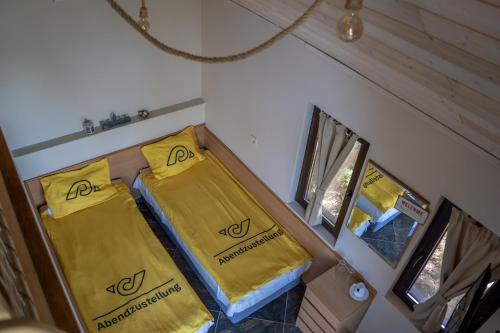 a small room with two beds with yellow sheets at Къщички Синьо лято, Черноморец - Варна - Blue Summer Houses Varna in Varna City