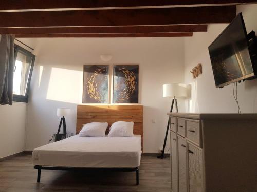 une chambre avec un lit et une télévision à écran plat dans l'établissement Duplex 4-6 pers - 33m2 - 180m de la plage, à Marseillan