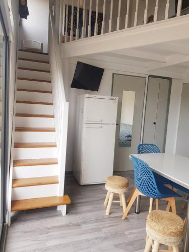 une cuisine avec un escalier, une table et des chaises dans l'établissement Duplex 4-6 pers - 33m2 - 180m de la plage, à Marseillan