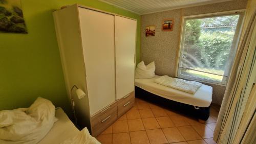 a small room with two beds and a window at Bungalow (hälfte) Steuerbord Ahlbeck (Usedom) in Ahlbeck