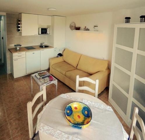 een woonkamer met een bank en een tafel bij Estudio con encanto a metros de la playa in Sitio de Calahonda