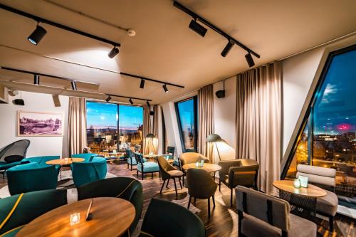 a restaurant with tables and chairs and large windows at Holiday Inn Gdansk - City Centre by IHG in Gdańsk