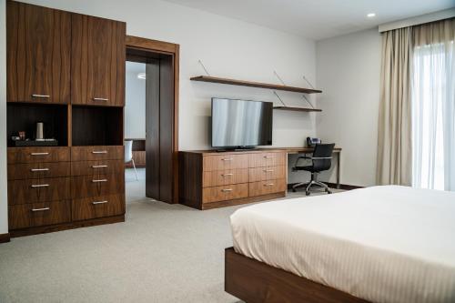 a hotel room with a bed and a flat screen tv at Gaya Residences in Shahdag