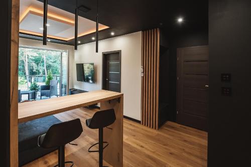 a kitchen and living room with a counter and chairs at Apartament Leśny-Cedzyna no62 TARGI Kielce Rowery !!! in Kielce