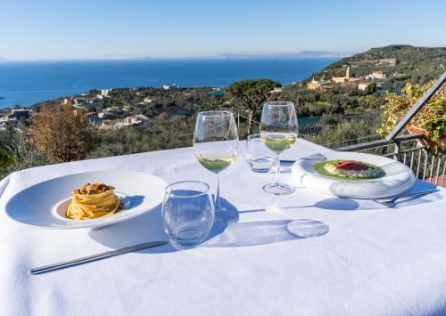 a table with a plate of food and wine glasses at Terrazza Iride in Massa Lubrense