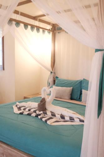 a bed with a pile of towels on it at Luz_ita Sunshine Villa in Uluwatu