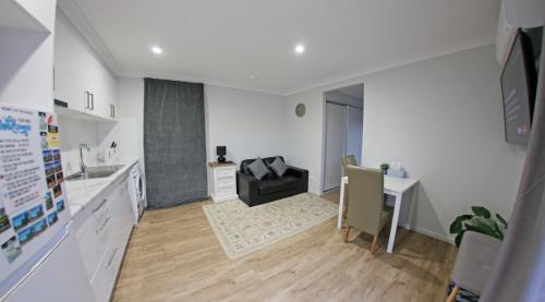 a kitchen and dining room with a table and a desk at Granny Flat next to golf course in Stanthorpe