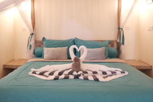 a bed with a blanket and a towel on it at Luz_ita Sunshine Villa in Uluwatu