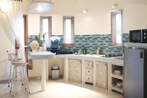 a kitchen with a sink and a refrigerator at Luz_ita Sunshine Villa in Uluwatu