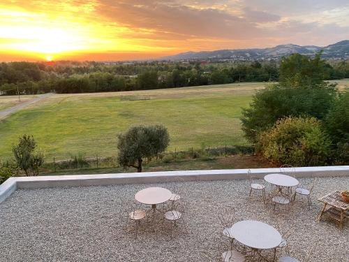 a patio with tables and chairs and a sunset at Christy House in Vignale