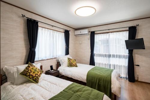 a hotel room with two beds and a window at KAMAKURA DEL COSTA in Kamakura