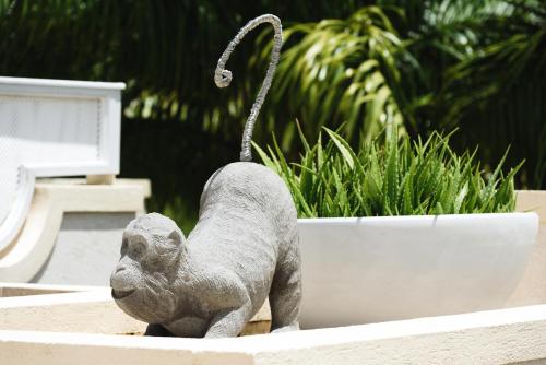 a statue of a cat sitting in a planter at Zenbreak KingsGate 1 in Saint Peter